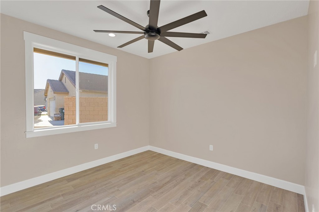 16618 Country Ranch Court Victorville, CA 92395 - Photo 21 of 31 an empty room with a window and a fan