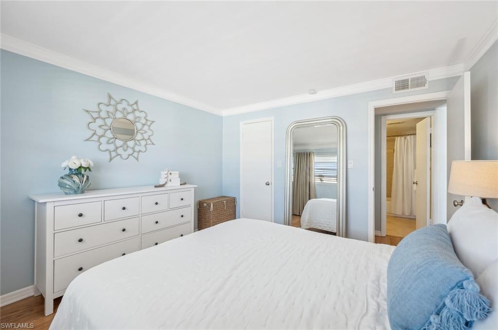 72 7th Street South, Unit 305 Naples, FL 34102 - Photo 11 of 26 a bedroom with a bed and a dresser