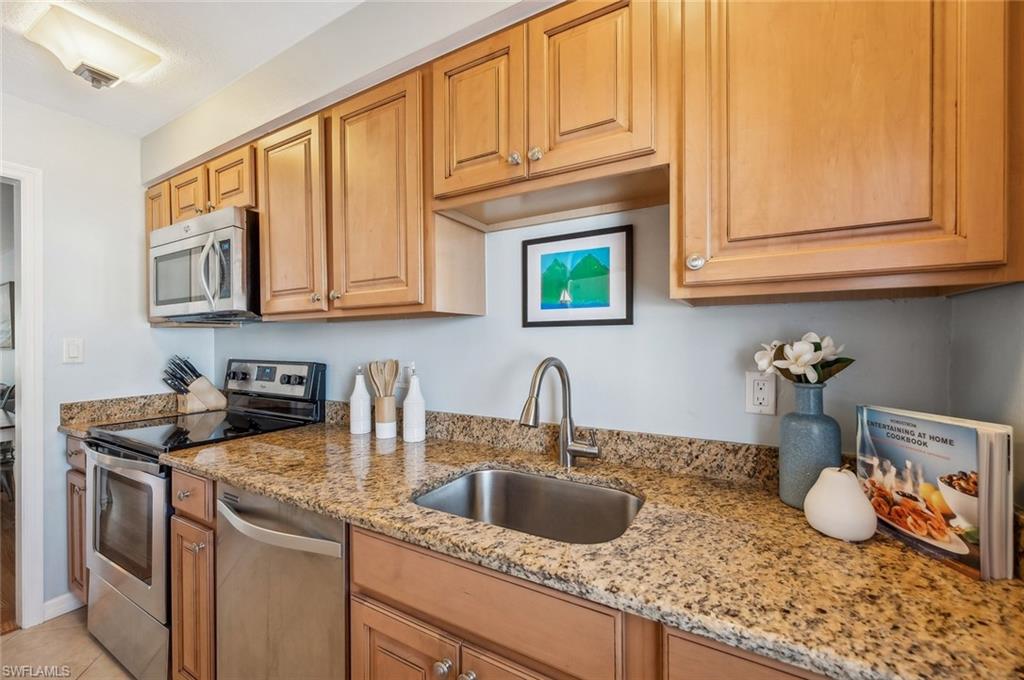 72 7th Street South, Unit 305 Naples, FL 34102 - Photo 6 of 26 a kitchen with stainless steel appliances granite countertop a sink a stove and cabinets