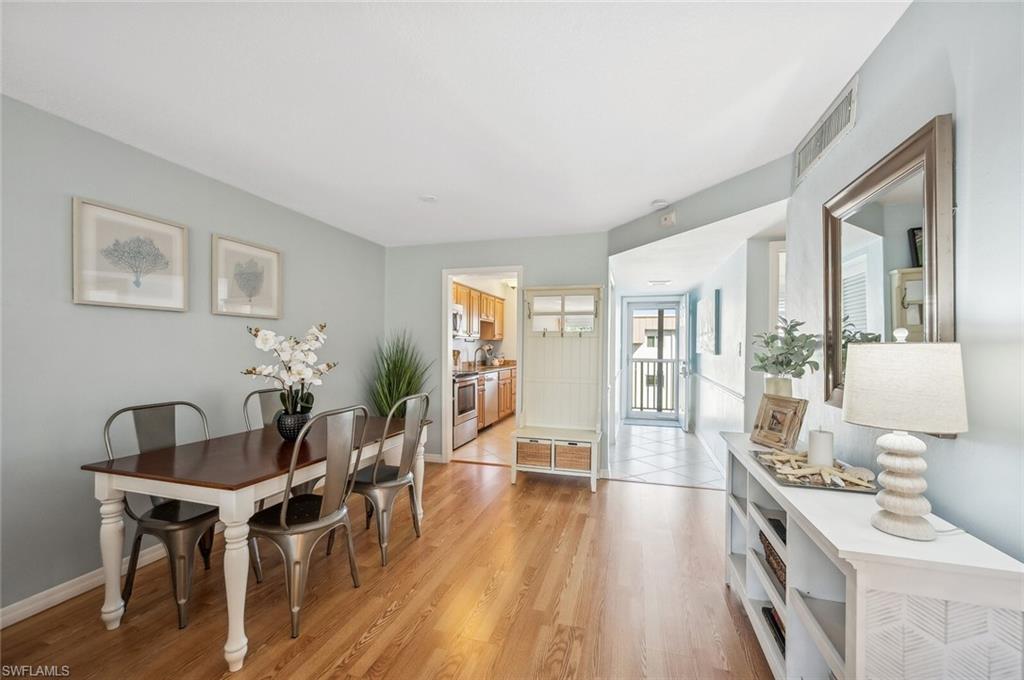 72 7th Street South, Unit 305 Naples, FL 34102 - Photo 9 of 26 a view of a dining room with furniture and wooden floor