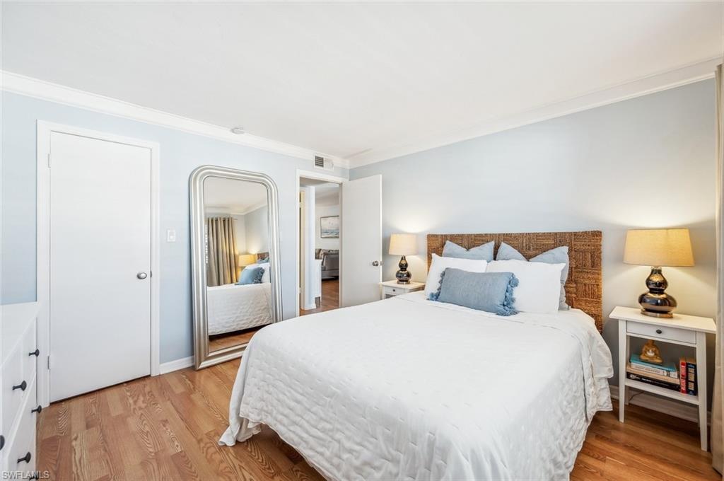 72 7th Street South, Unit 305 Naples, FL 34102 - Photo 10 of 26 a bedroom with a bed and wooden floor