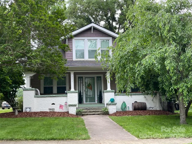 a front view of a house with a yard and trees