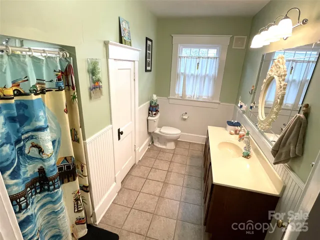 a view of a livingroom with a fireplace a ceiling fan and wooden floor