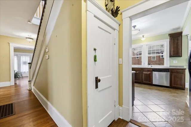 a view of a hallway with wooden floor and staircase