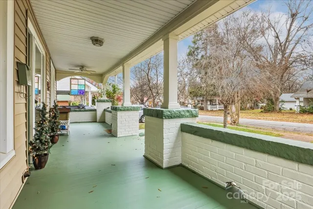 a backyard of a house with sofas table and chairs