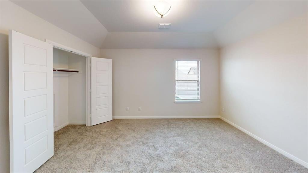 1840 Rosedale Avenue Van Alstyne, TX 75495 - Photo 13 of 24 Spacious room featuring neutral carpet flooring, a window with blinds, and a built-in closet with bifold panel doors and a hanging rod