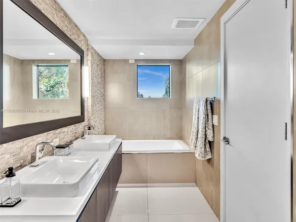 a bathroom with a tub sink and mirror