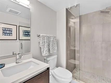 a bathroom with a sink toilet vanity and shower