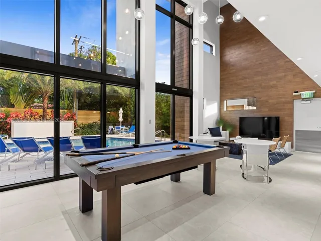 a living room with couches a mirror and a clock on table with wooden floor