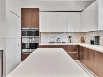 a kitchen with stainless steel appliances a sink a stove a microwave and cabinets