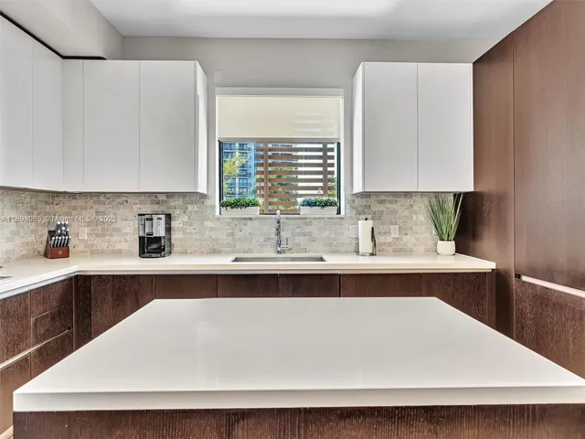 a kitchen with a sink a window and cabinets