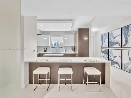a kitchen with a sink and chairs