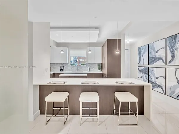 a kitchen with a sink and chairs