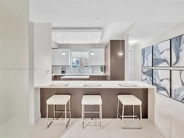 a kitchen with a sink and chairs