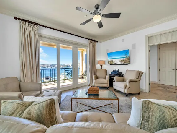 a living room with furniture kitchen view and a chandelier
