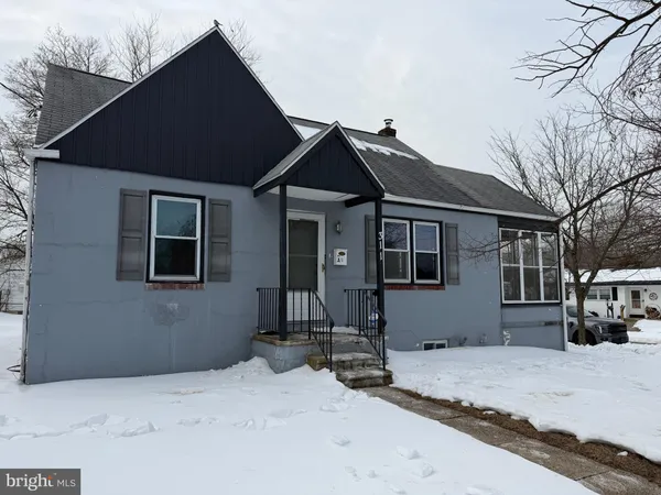 a front view of a house with a yard covered in snow