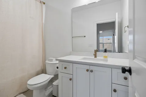 a bathroom with a granite countertop sink a toilet and a mirror