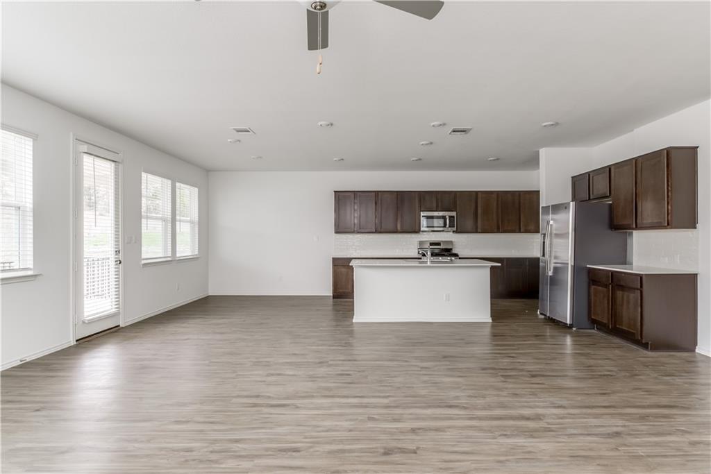 712 Affazia Lane Georgetown, TX 78628 - Photo 5 of 40 a view of kitchen with stainless steel appliances wooden floor and large window