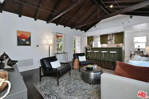 a kitchen with stainless steel appliances granite countertop a table chairs sink and cabinets
