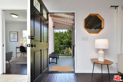 a living room with furniture a flat screen tv and next to a window
