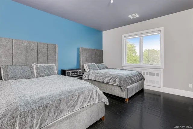 a bedroom with two beds and a wooden floor