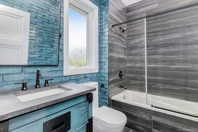 a bathroom with a granite countertop sink toilet and shower