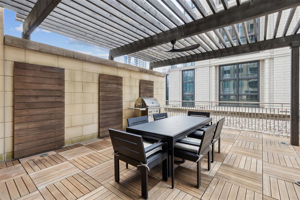 2300 Wolf Street, Unit 3D Dallas, TX 75201 - Photo 29 of 37 a view of a patio with table and chairs with wooden floor and fence