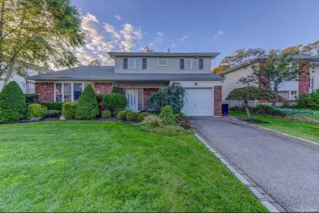 a front view of a house with a yard and a garage