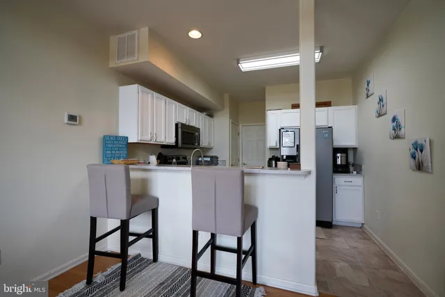 a kitchen with stainless steel appliances kitchen island granite countertop a refrigerator and microwave