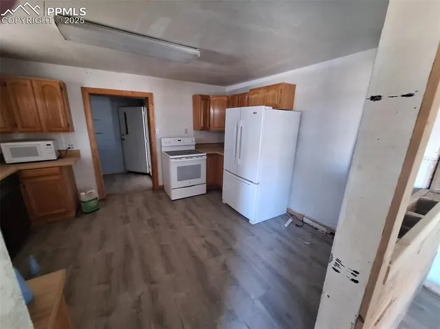 a view of kitchen with refrigerator stove and wooden floor