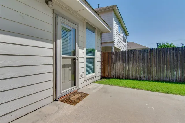 a view of backyard with tub and wooden fence