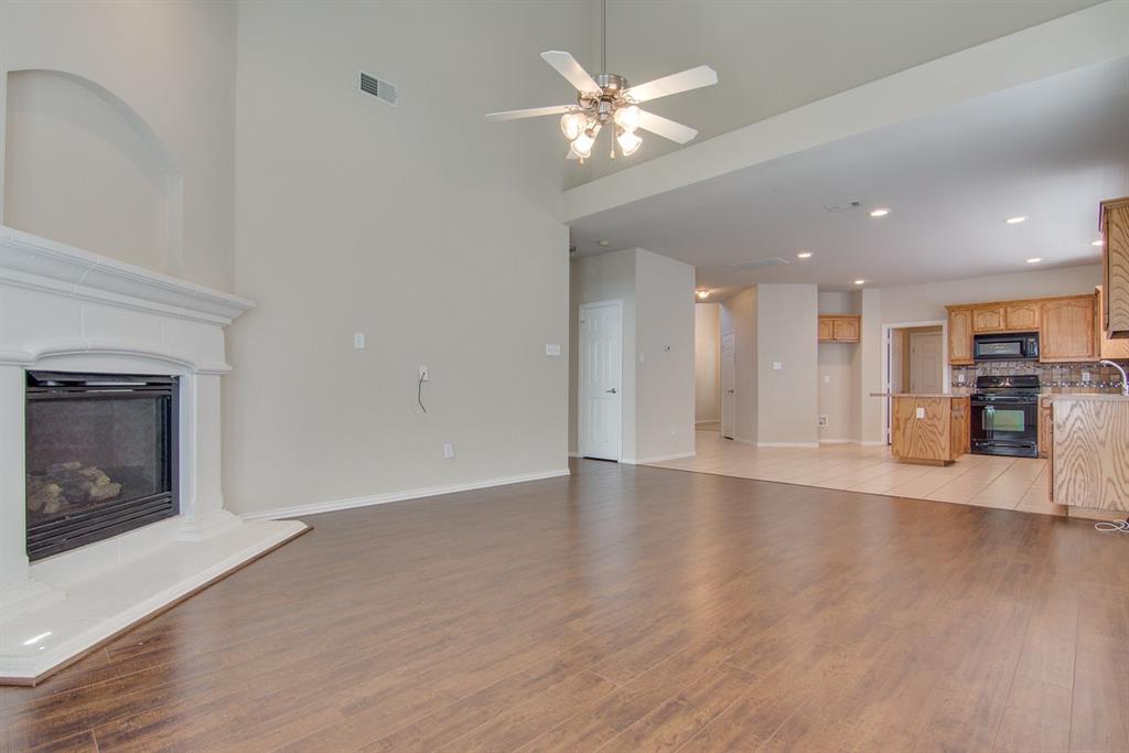 11800 Porcupine Drive Fort Worth, TX 76244 - Photo 4 of 12 an empty room with wooden floor fireplace cabinet and windows