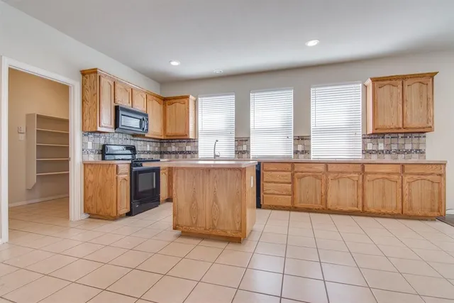 a kitchen with stainless steel appliances a stove a sink a microwave a counter top and cabinets