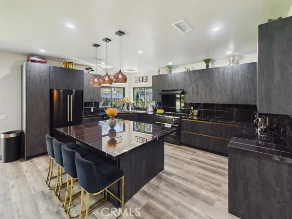 a kitchen with stainless steel appliances granite countertop a sink a stove and a refrigerator