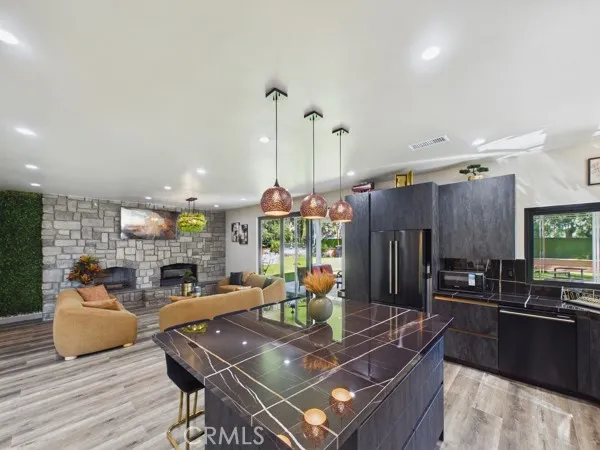 a living room with furniture kitchen view and a chandelier