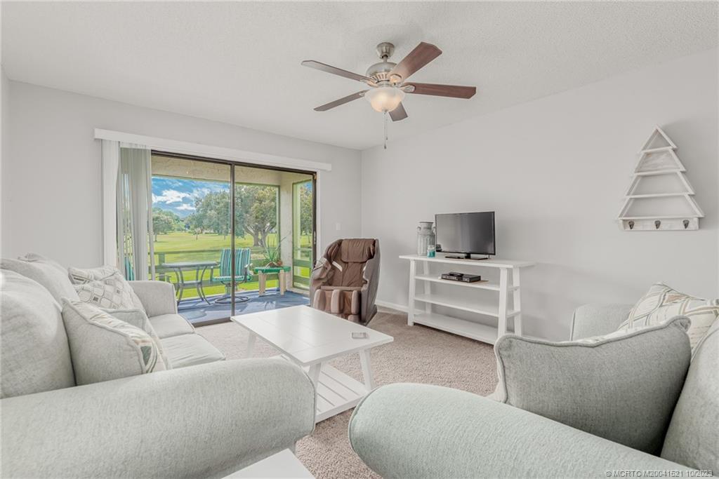 5433 Southeast Miles Grant Road, Unit 203 Stuart, FL 34997 - Photo 11 of 31 a living room with furniture and a large window