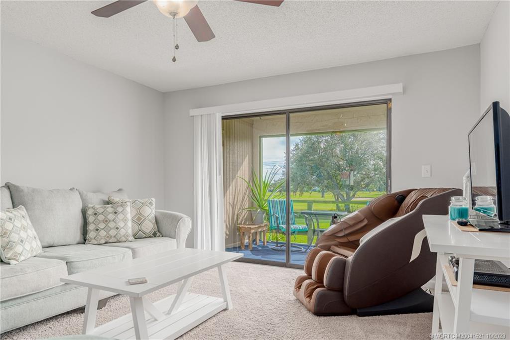 5433 Southeast Miles Grant Road, Unit 203 Stuart, FL 34997 - Photo 12 of 31 a living room with furniture and a large window