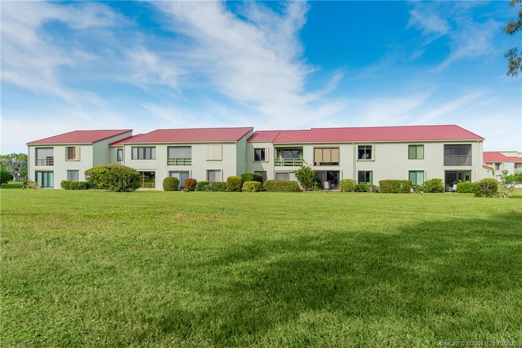 5433 Southeast Miles Grant Road, Unit 203 Stuart, FL 34997 - Photo 13 of 31 a city view with tall buildings and a yard