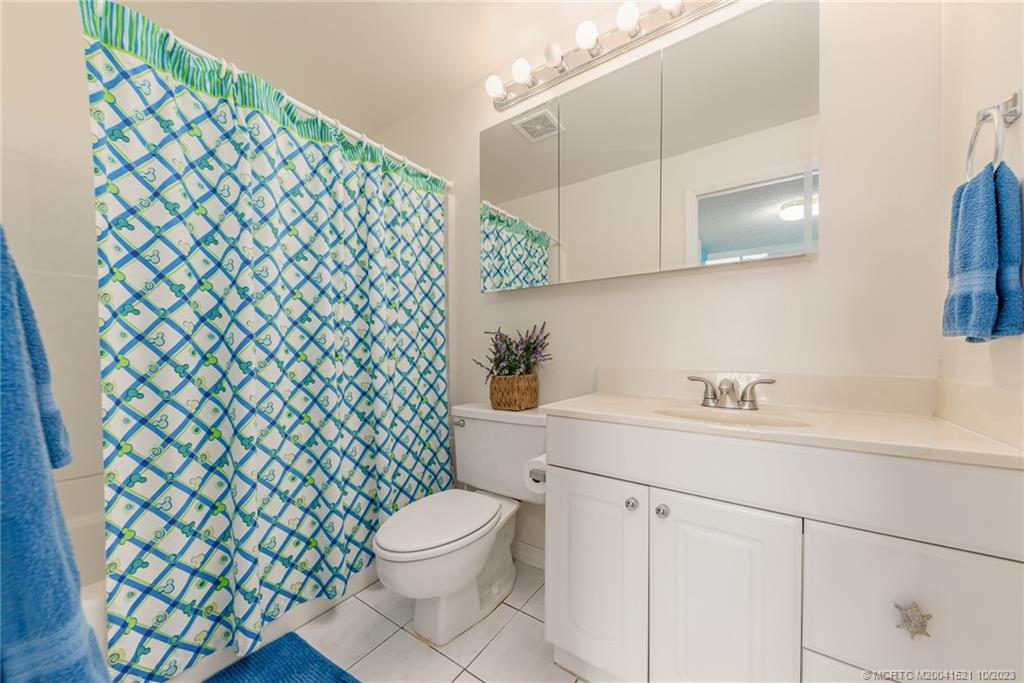 5433 Southeast Miles Grant Road, Unit 203 Stuart, FL 34997 - Photo 16 of 31 a bathroom with a sink a toilet and a mirror