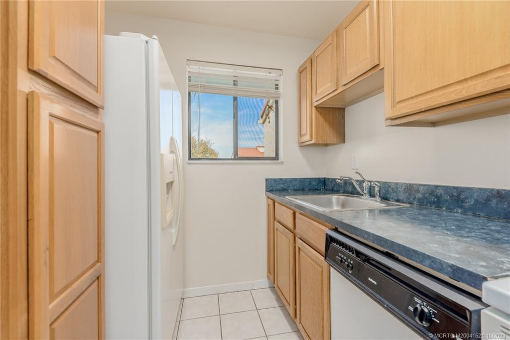 5433 Southeast Miles Grant Road, Unit 203 Stuart, FL 34997 - Photo 9 of 31 a kitchen with a sink and cabinets
