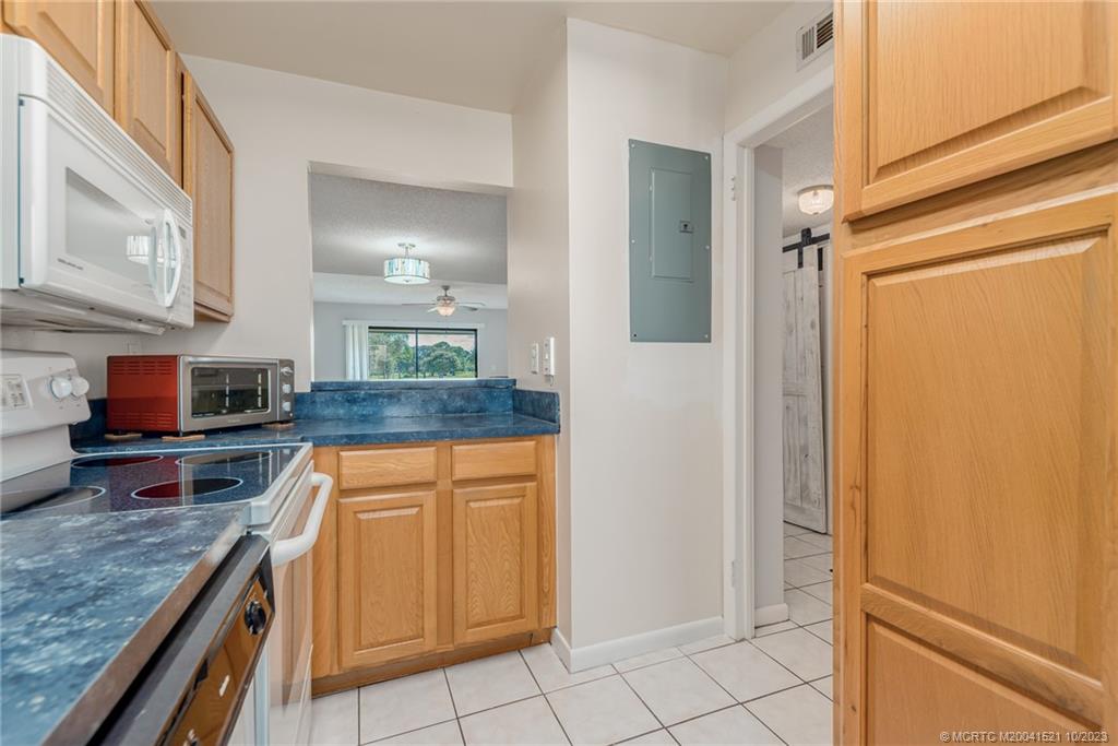 5433 Southeast Miles Grant Road, Unit 203 Stuart, FL 34997 - Photo 10 of 31 a kitchen with stainless steel appliances granite countertop a refrigerator and a stove