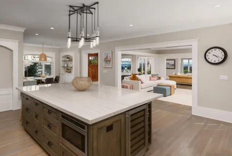 a kitchen with stainless steel appliances granite countertop a sink dishwasher a stove a dining table and chairs with wooden floor