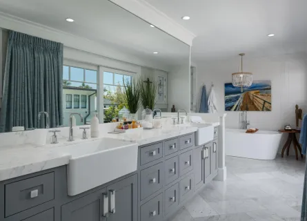 a bathroom with double vanity sinks a large mirror and a bath tub