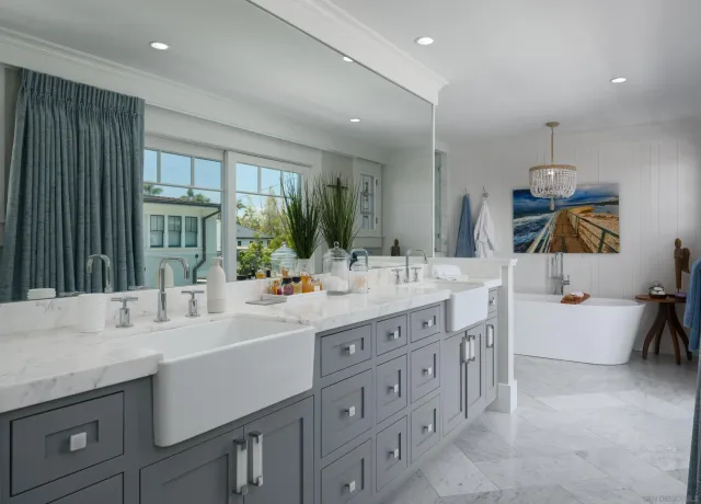 a bathroom with double vanity sinks a large mirror and a bath tub