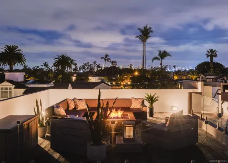 a view of roof deck with furniture and ocean view
