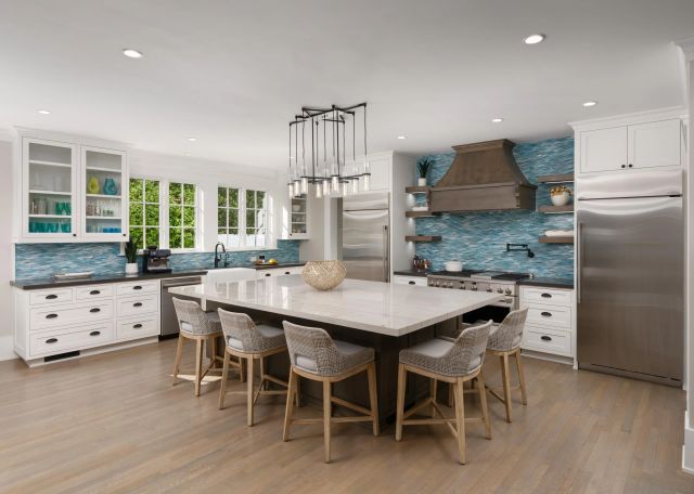 a kitchen with stainless steel appliances kitchen island granite countertop a table chairs sink and cabinets