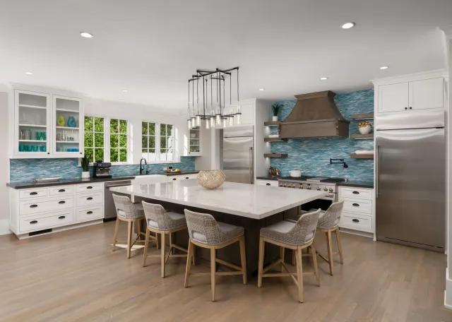 a kitchen with stainless steel appliances kitchen island granite countertop a table chairs sink and cabinets