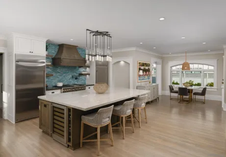 a kitchen with stainless steel appliances a table chairs and wooden floor