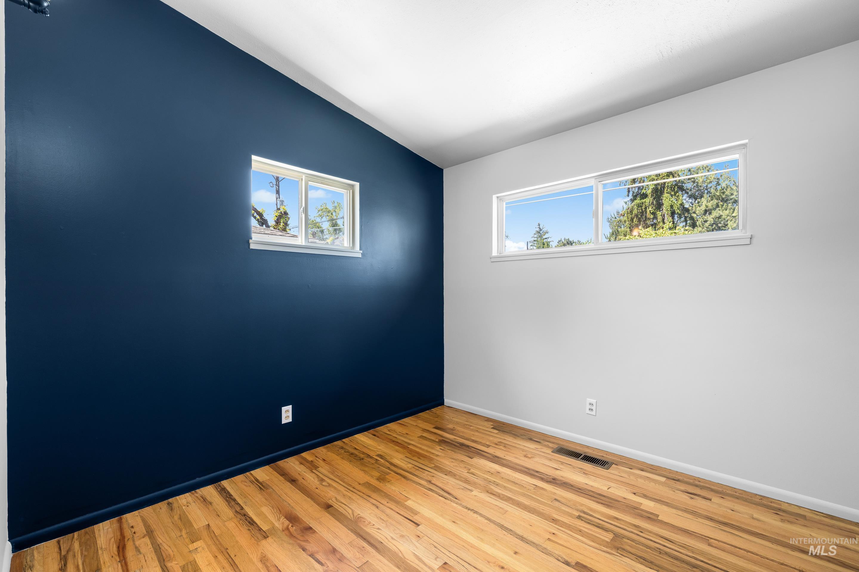 708 South Phillippi Street Boise, ID 83705 - Photo 17 of 25 Spacious room featuring wood-finish flooring and two distinct window styles
