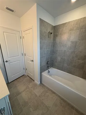 a white bath tub sitting next to a white sink and vanity